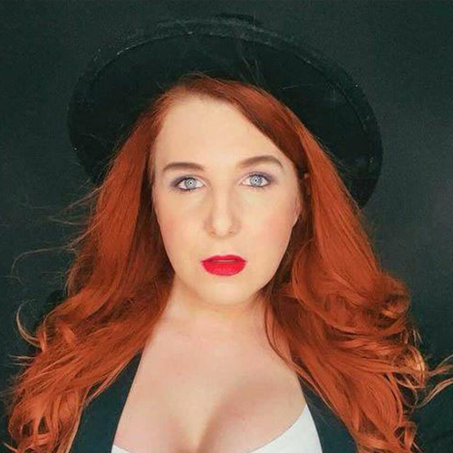 Miri Leonardo, dunkler Hintergrund, Hut, rote Haare, sexy Blick