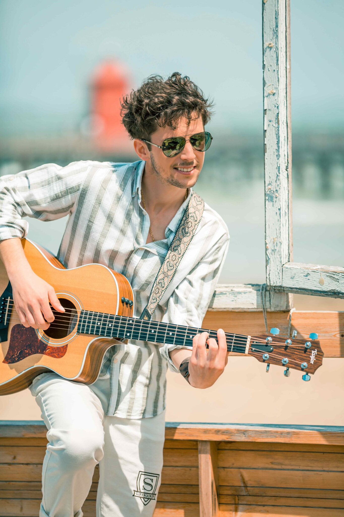 Manuel Spitzer, Lächeln, Sonnenbrille, Gitarre, blauer Hintergrund