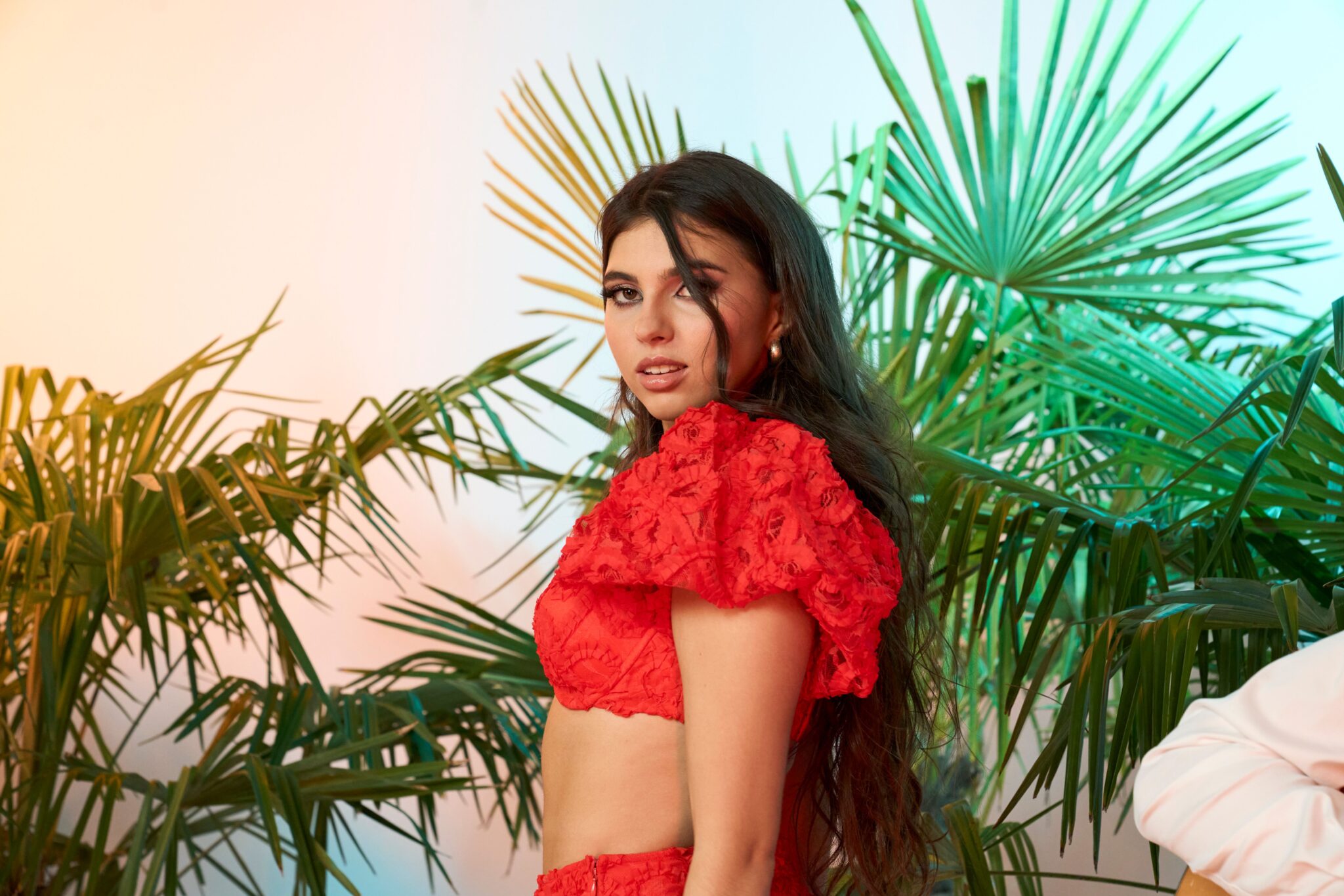 Maibritt Egger, rotes Kleid, Palmen im Hintergrund, sexy Blick