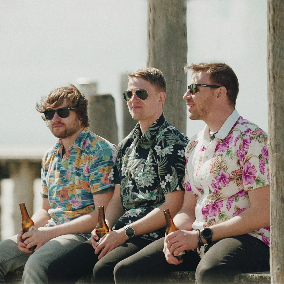 Crowdfleckerl, drei Männer, Bierflaschen, grauer Hintergrund, Ufer, Pier, Hawaii-Hemden