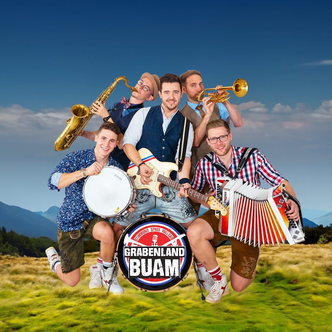 Grabenland Buam, Gras, Berge im Hintergrund, blauer Himmel, fünf Personen, Drums, Blasinstrumente, Steirische Harmonika