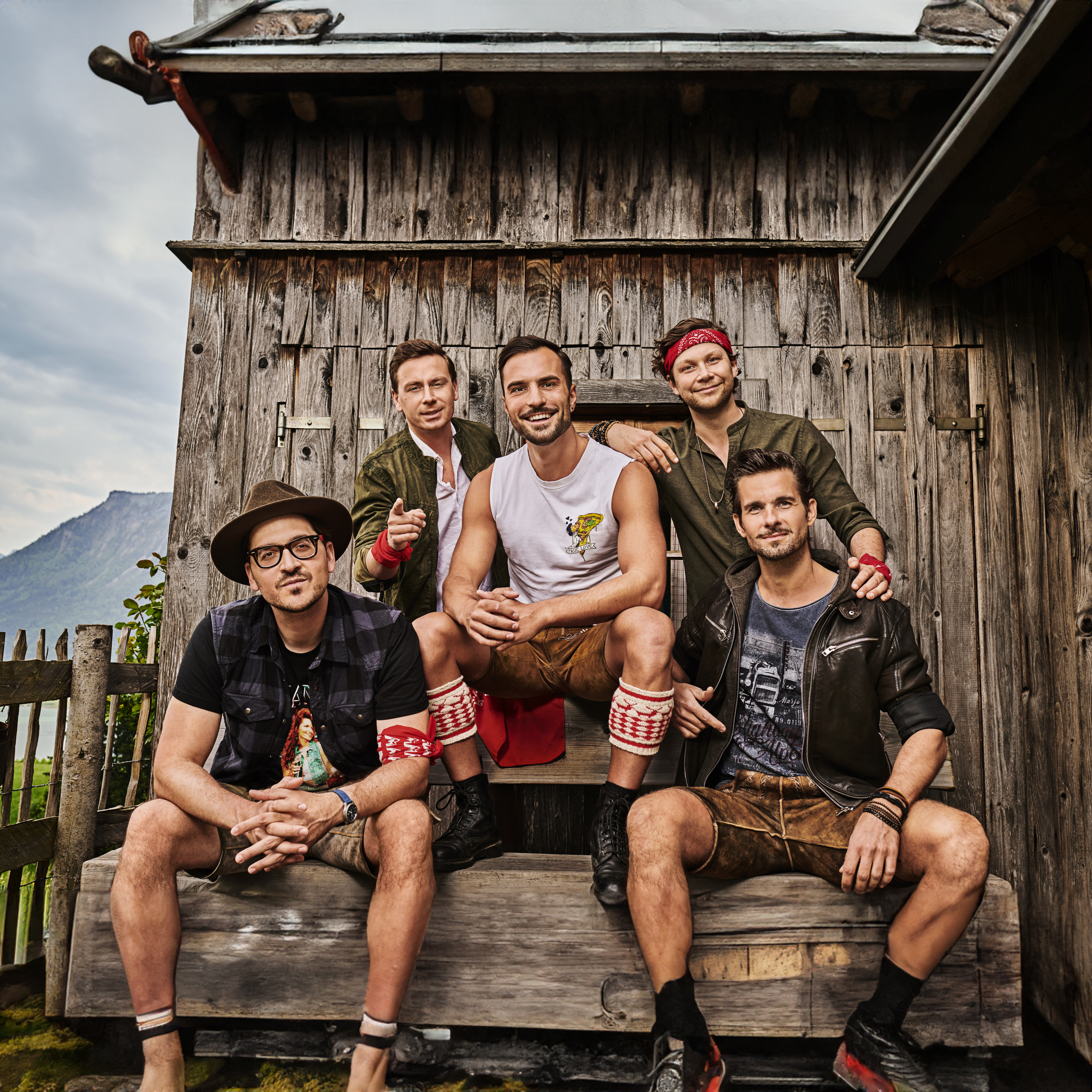 Mountain Crew, fünf Personen, Boygroup, Holzhütte im Hintergrund, Lächeln, bewölkt